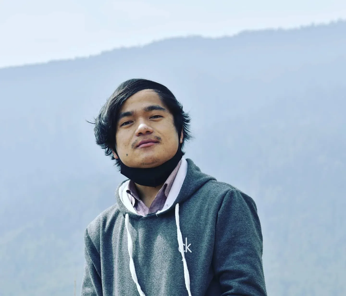 Sujan Mongar, founder of nine75, standing in front of a forested hillside